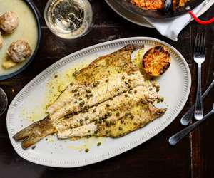Whole Bronzino grilled over an open flame.